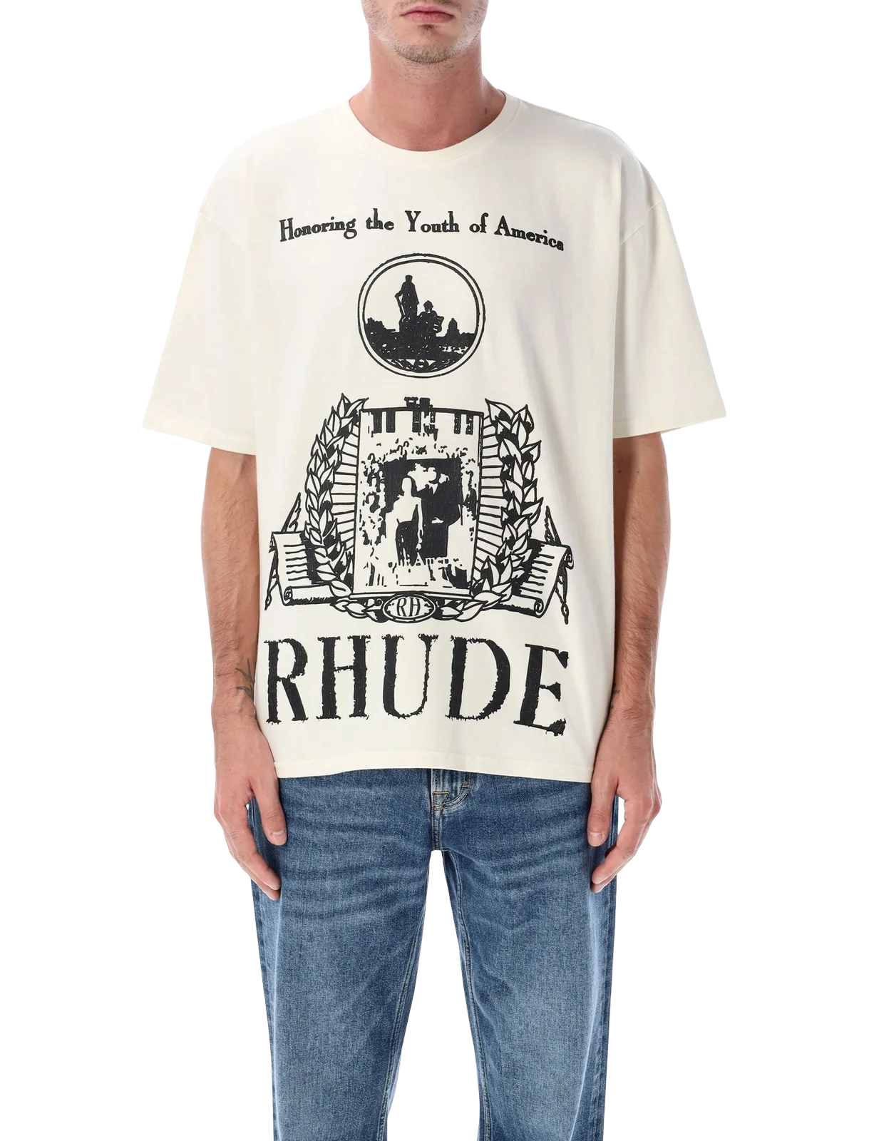 Model wearing Rhude Youth of America Tee with large black graphic crest print paired with jeans